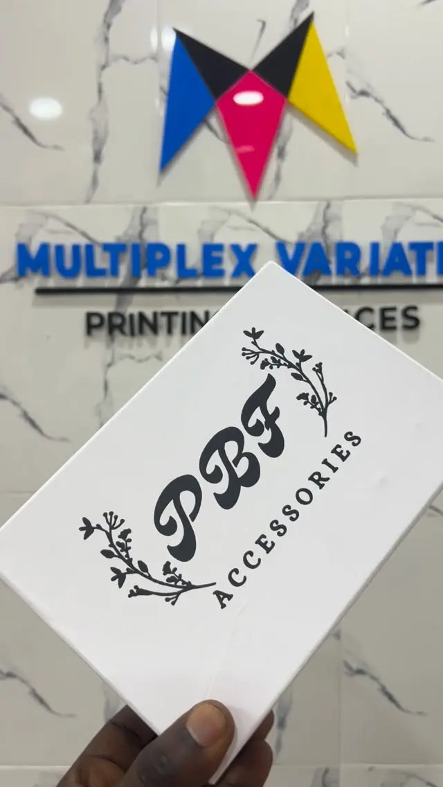 A printed card held in front of the Multiplex logo wall