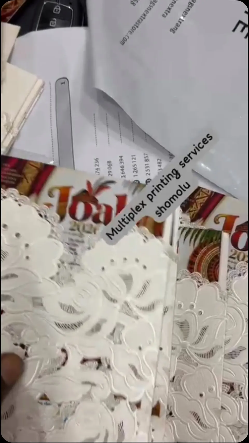 A lace wedding invitation in front of the Multiplex wall